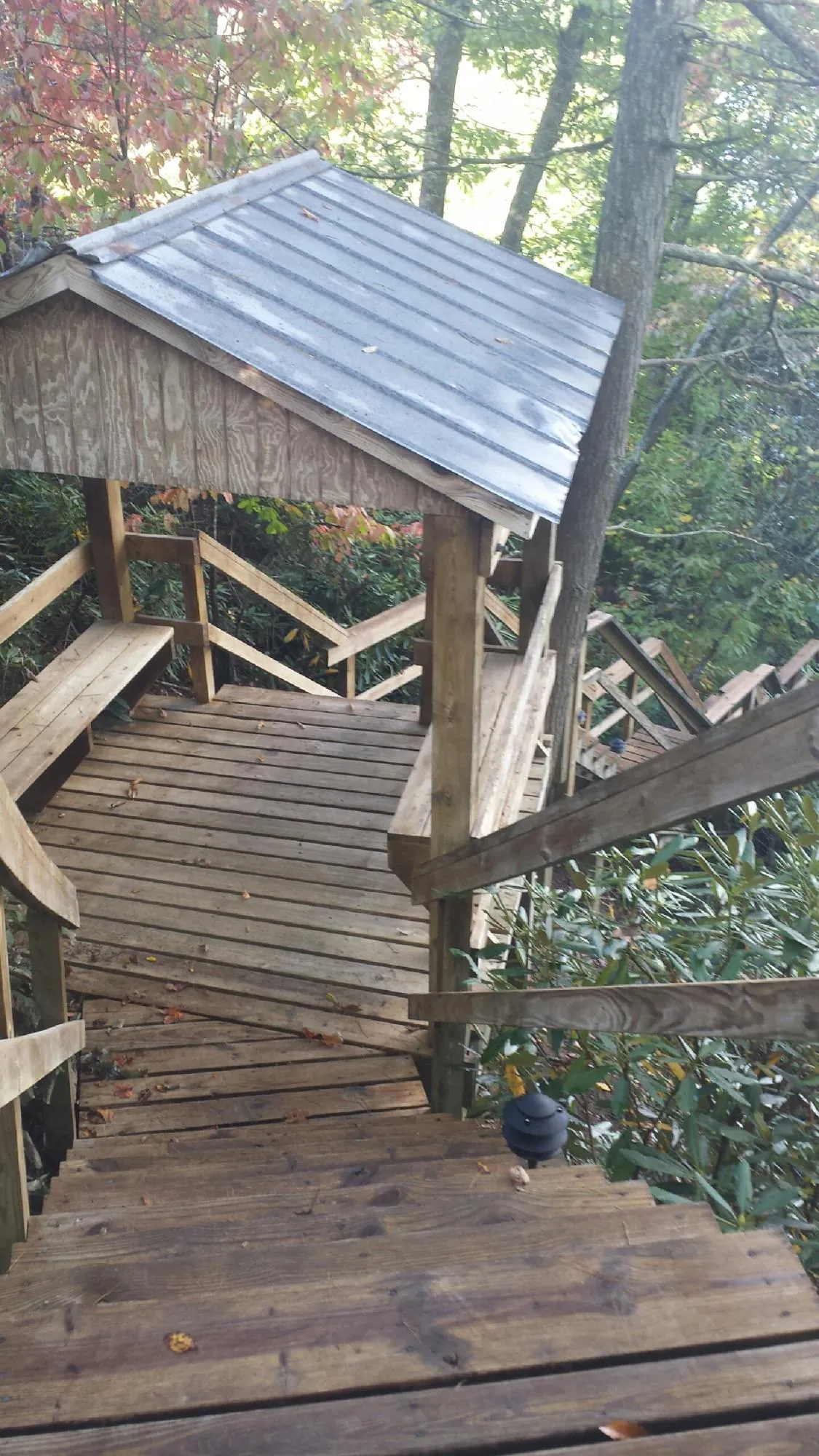 Metal roofed shelter over wooden steps on a wooded walkway — Skylight Repair & Installation work by our crew in East Berlin