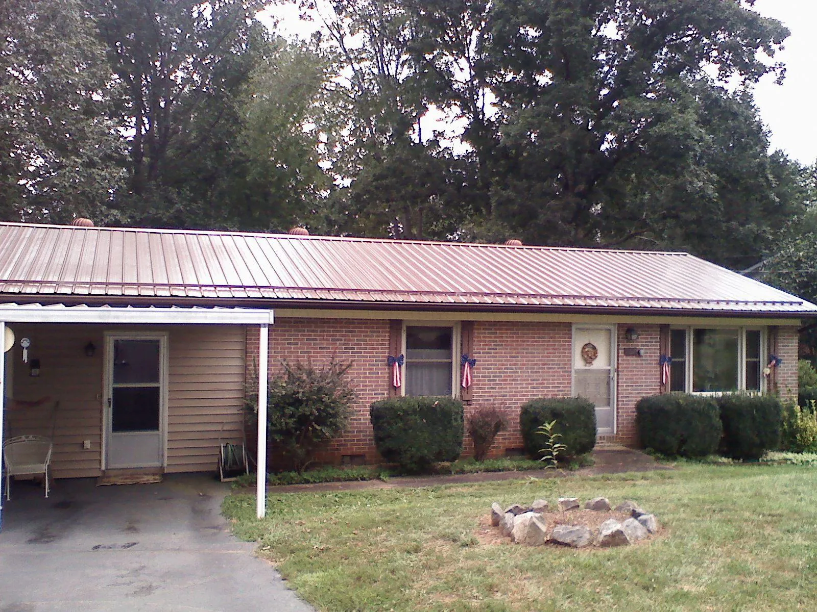 Bronze metal roof and carport on a brick ranch home — Roof Repair work by our crew in East Berlin